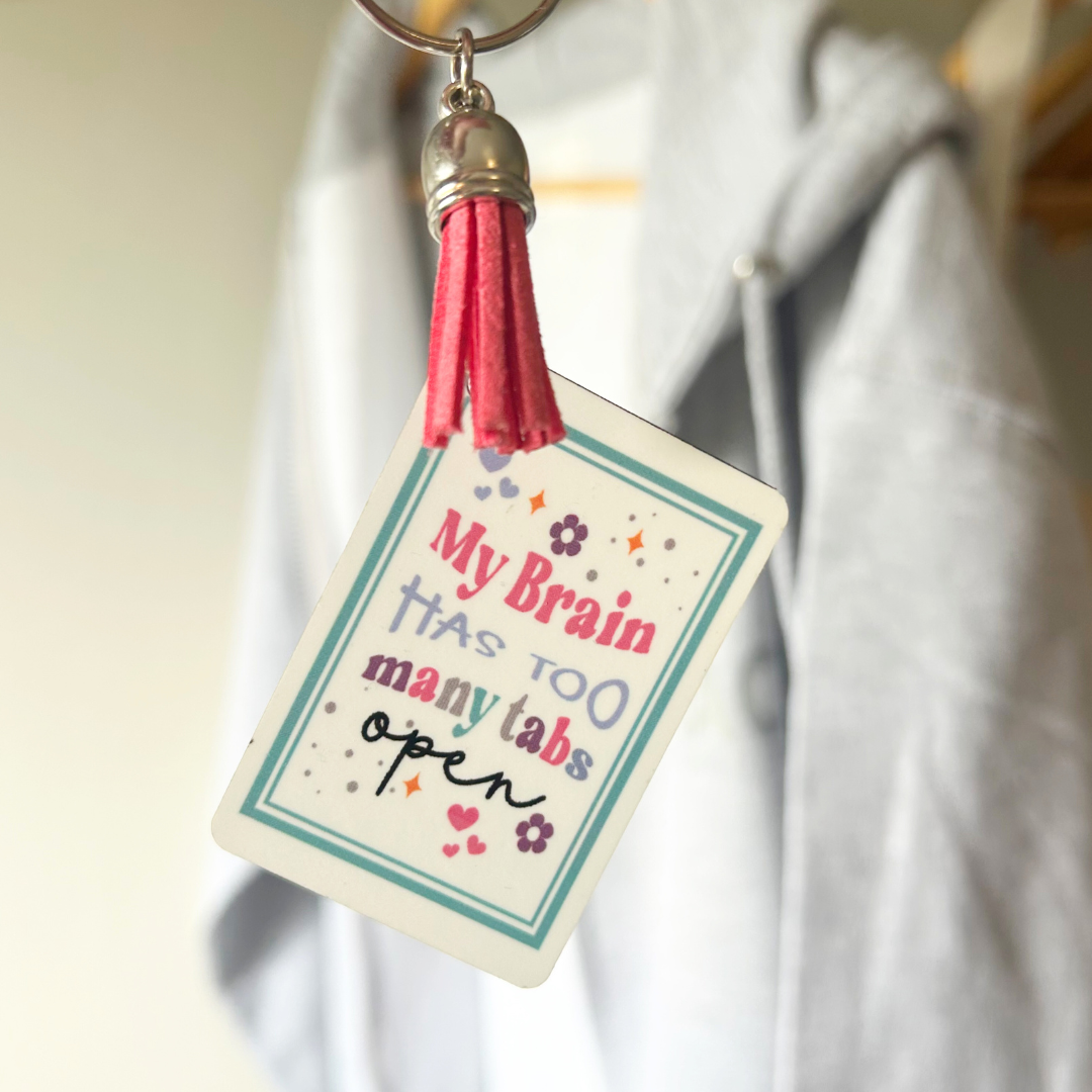 Rectangle MDF Keychain with white gloss layer and deign that says 'My Brain Has Too Many Tabs Open'. Comes with coloured tassel and chain.
