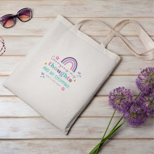 Natural Cream cotton tote bag with shoulder straps and rainbow design with the wording 'Carrying my thoughts and my shopping. Both a little heavy'.